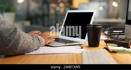 La technologie me permet de rester connecté par e-mail. un homme d'affaires méconnu assis seul et travaillant sur son ordinateur portable dans son bureau tard dans la nuit. Banque D'Images