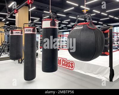 Anapa, Russie 19 mai 2022: Gymnase de classe mondiale, sac de poinçonnage rouge et noir avec fond de gym Banque D'Images