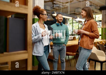 Une équipe d'affaires diversifiée riant avec joie dans un bureau de collègue Banque D'Images