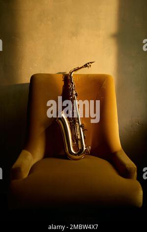Instrument de musique saxophone laissé sur la chaise dans la salle rétro Banque D'Images