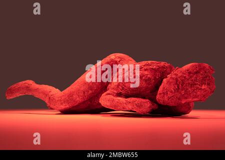 Plâtre moulé d'un corps, trouvé dans l'ancienne ville de Pompéi, exposé et illuminé avec des lampes rouges dans un musée Banque D'Images