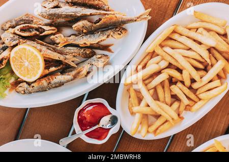 frites et poissons grillés. poisson et frites. Plat avec poisson-mulet à l'orange. Friture de petits poissons frits Banque D'Images