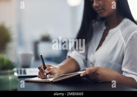 Noter quelques grands projets. Gros plan d'une femme méconnue qui écrit des notes dans un bureau. Banque D'Images