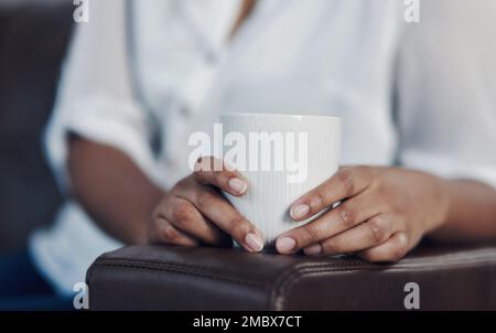 Détendez-vous dans le salon du bureau avec un peu de caféine. Gros plan d'une femme d'affaires méconnue qui boit du café tout en prenant une pause dans un bureau. Banque D'Images