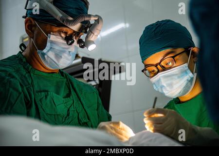 220623-N-AU520-2021 TUY HOA, VIETNAM (23 juin 2022) – Cmdr. Tim Kim (à gauche), ophtalmologiste à bord du navire USNS Mercy (T-AH 19) du Commandement militaire du Sealift, et Huynh Nguyen Ngoc Huyen (à droite), ophtalmologiste vietnamien, effectuent une opération de réduction des paupières sur un patient vietnamien à l'hôpital Ophthalmologie Phu yen durant le Pacific Partnership 2022. En 17th ans, le Partenariat Pacifique est la plus importante mission multinationale annuelle d'aide humanitaire et de préparation aux secours en cas de catastrophe menée dans l'Indo-Pacifique. Banque D'Images