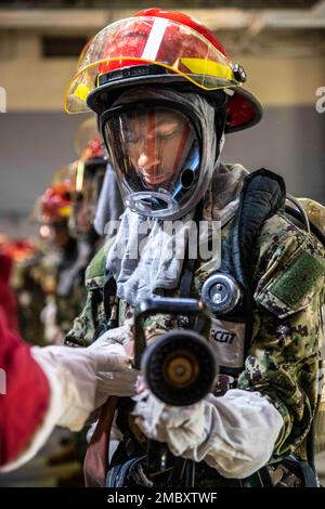 220623-N-PW480-0175 GRANDS LACS, ILLINOIS (23 juin 2022) – Un candidat de sage-navire Du corps d'instruction des officiers de la Réserve navale (NROTC) nouvel indoctrination étudiante (NSI) montre la bonne façon d'utiliser le tuyau lors d'un exercice d'entraînement de lutte contre les incendies et de contrôle des dommages à l'intérieur de l'USS Chief Fire Fighter Trainer au Commandement de l'instruction de recrutement (RTC), 23 juin. À la fin de l'INS, les candidats débuteront leur première année du programme NROTC dans les collèges et universités de tout le pays cet automne. NSI est un programme d'endoctrinement hébergé au CCF, et fournit aux sages-navires une orientation commune en matière d'entraînement militaire Banque D'Images