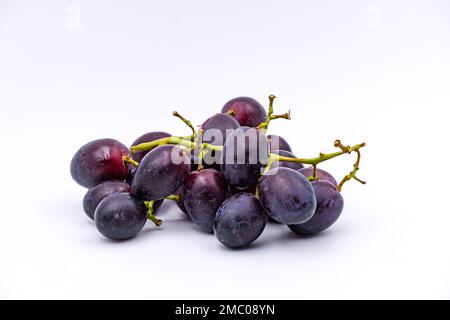 Une panicule de raisin bleu mûr photographié avec une grande profondeur de champ et rogné sur fond blanc Banque D'Images