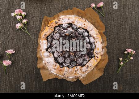 Tarte aux prunes maison aux raisins secs sur fond de bois. Banque D'Images