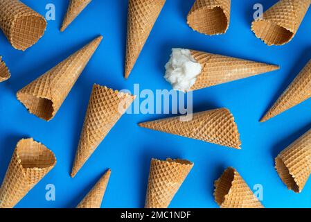 Crème glacée et gaufres, cornets de crème glacée vides sur fond bleu. Banque D'Images