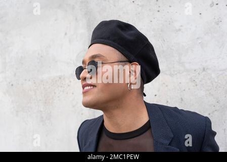 Jeune gays latins avec maquillage portant un chapeau et des lunettes de soleil à la mode, isolés sur un fond blanc. LGBT Banque D'Images