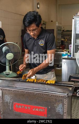 Man Cooking Satay, Malaisie Banque D'Images