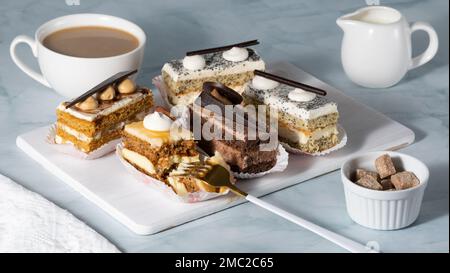 Un ensemble de délicieux gâteaux et café sur une table légère Banque D'Images