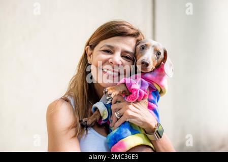 Femme latine tenant son chien. Les deux sont habillés comme l'appareil photo Banque D'Images