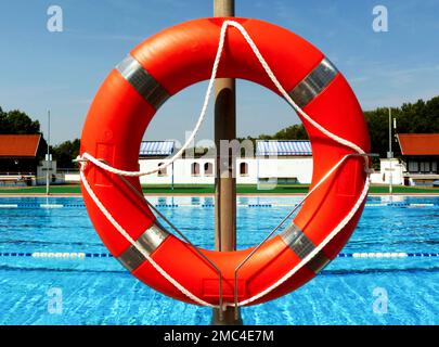 anneau de protection en plastique de couleur orange. dispositif de sauvetage d'eau. piscine extérieure. journée ensoleillée. préparation et concept de sécurité. sports nautiques Banque D'Images