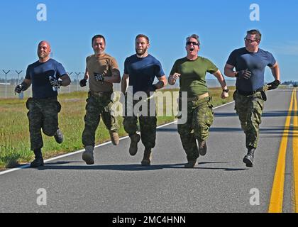 La Force aérienne royale du Canada, 2 escadron des mouvements aériens, se présente à la ligne d'arrivée du défi de conditionnement physique au combat lors du rodéo de Port Dawg à la base interarmées Lewis-McChord, Washington (23 juin 2022). Quatorze équipes de Port dawgs du monde entier ont participé à cinq événements afin de gagner l'honneur de Top Dawg : un concours de construction de palettes, un cours de compétences en chariots élévateurs de 10k, un chargement de 25K avions de chargement, un défi de forme physique au combat et un test de connaissances du centre d'équilibre. Banque D'Images