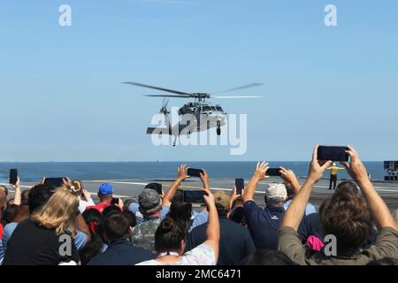 Les marins, leur famille et leurs amis observent un MH-60S Nighthawk, attaché aux « Tridents » du Helicopter Sea combat Squadron (HSC) 9, lors de la croisière d’une journée entre amis et famille de l’USS Gerald R. Ford (CVN 78), le 25 juin 2022. Amis et membres de la famille ont été invités à bord de Ford pour vivre une journée dans la vie d'un marin en mer de première main. CONAC, CVN78, Journée de la famille, US Navy, USS Gerald R. Ford (CVN 78), Banque D'Images