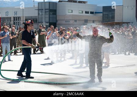 Le lieutenant-colonel Todd Hudson, chef de la sécurité de l'escadre du transport aérien 152nd et navigateur de la Garde nationale aérienne du Nevada C-130, est vaporisé d'un tuyau d'incendie et de champagne par sa famille et ses amis après son dernier vol avec la Garde nationale aérienne du Nevada à Reno, au Nevada, au 25 juin 2022. La pulvérisation de boyaux d’incendie et de champagne fait partie d’une tradition qui célèbre le dernier vol d’un membre d’équipage avec son unité ou sur un certain aéronef. Banque D'Images