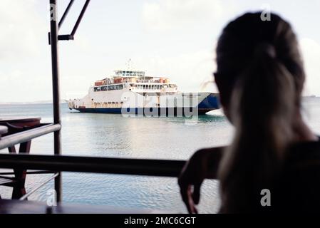 Silhouette d'une femme regardant le Ferry-Boat arrivant au terminal maritime de la ville de Salvador, Brazi Banque D'Images