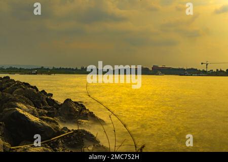 Rochers sur la plage pendant le coucher du soleil à la Marina Beach Semarang. Indonésie. Banque D'Images