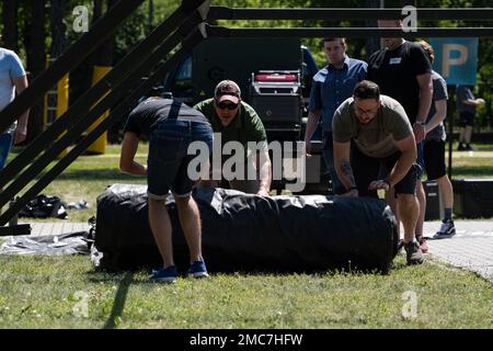 ÉTATS-UNIS Le Sgt Brent Kenney, maître principal de la Force aérienne, du surintendant des réparations lourdes (au centre) du 52nd Escadron du génie civil, dirige les bénévoles dans la mise en place du système du projet Arcwater à Otlock, en Pologne, en 26 juin 2022. Arcwater peut entièrement fournir une tente avec de l'énergie, des téléviseurs en fonctionnement, un système de climatisation et plus principalement en utilisant l'énergie solaire. Banque D'Images