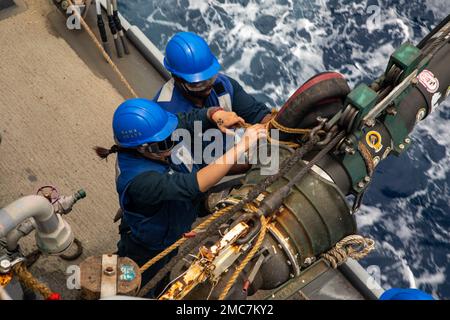 MER DE CHINE ORIENTALE (26 juin 2022) le compagnon de Boatswain classe 3rd Ashley Iuli, à gauche, de Los Angeles, Et le Mate 2nd de Boatswain classe Jarod Smith, à droite, de Jacksonville, Floride, relient une ligne de carburant à bord du destroyer à missiles guidés de classe Arleigh Burke USS Dewey (DDG 105) lors d'un ravitaillement en mer avec le navire de fret sec de classe Lewis et Clark USNS Cesar Chavez (T-AKE-14). Dewey est affecté au commandant de la Force opérationnelle 71/Escadrier Squadron (DESRON) 15, la plus grande force de surface déployée à l’avant de la Marine et la principale force de surface de la flotte américaine 7th. Banque D'Images