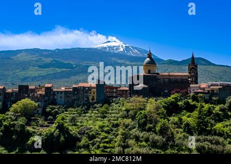 Vue sur l'église basilique de Santa Maria Assunta et les maisons de la ville de Randazzo, les pentes vertes et le sommet du volcan Etna, Mongibel Banque D'Images