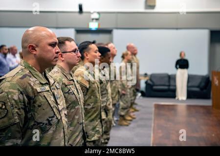 Des aviateurs et des gardiens de l'aile de soutien au combat 501st sont à l'attention lors d'une cérémonie d'Assomption du commandement à la RAF Broughton, en Angleterre, au 27 juin 2022. Une prise de commandement est une tradition militaire qui représente l’obtention formelle de l’autorité et de la responsabilité d’une unité par un commandant. Banque D'Images