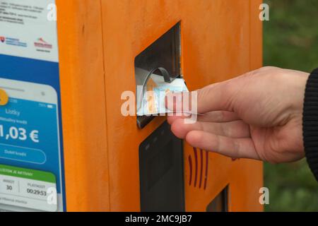 La main d'une femme achète un billet dans une machine à billets. Banque D'Images