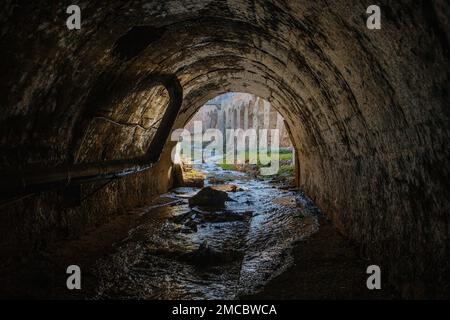 Sortez du tunnel d'égout voûté. Rivière souterraine, vue de l'intérieur du tunnel d'égout. Banque D'Images