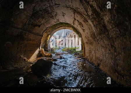 Sortez du tunnel d'égout voûté. Rivière souterraine, vue de l'intérieur du tunnel d'égout. Banque D'Images