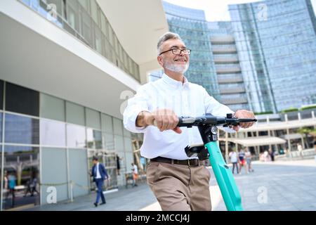 Un homme heureux utilisant l'application mobile pour la location de vélos dans le parc de la ville. Banque D'Images