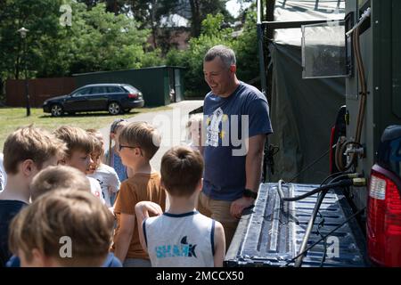 ÉTATS-UNIS Le Sgt Brent Kenney, maître principal de la Force aérienne, surintendant des réparations lourdes de l'escadron du génie civil 52nd, parle aux enfants polonais et ukrainiens du projet Arcwater dans un camp d'été à Ottock, en Pologne, en 29 juin 2022. Le camp d'été, qui utilise les arts pour enseigner l'anglais aux jeunes enfants, aurait une fois de plus été annulé si U.S. Les aviateurs de la Force aérienne de la Fighter Wing Wing 52nd de la base aérienne de Spangdahlem, en Allemagne, ne se sont pas joints cette année. Banque D'Images