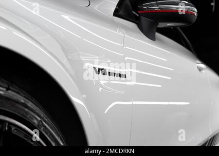 L'emblème bi-turbo V8 noir brillant sur le côté D'Une Mercedes 2016 C63s AMG Edition 1 blanche avec des boîtiers de miroir en fibre de carbone Banque D'Images