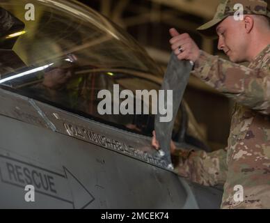 Le sergent d'état-major de la Force aérienne des États-Unis, Ryan Gurrieri, chef d'équipage du 35th Escadron de maintenance d'aéronefs, dévoile un nom pour le colonel Michael P. Richard, commandant de la 35th escadre de combat (FW), à bord de son faucon de combat F-16 lors de la cérémonie de changement de commandement de la FW 35th à la base aérienne de Misawa, au Japon (30 juin 2022). La cérémonie de passation de commandement a officiellement transféré le commandement du 35th FW du colonel Jesse J. Friedel, commandant sortant du 35th FW, à Richard. Banque D'Images