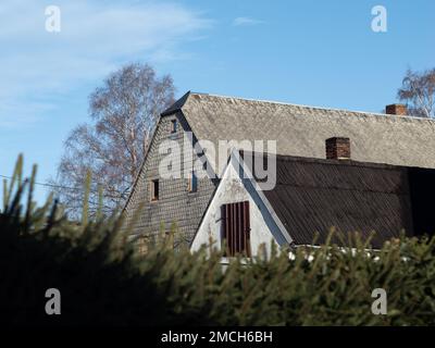 Ancienne maison avec des feuilles d'amiante sur le mur extérieur et sur le toit. Les plaques de ciment altérées avec des fibres sont interdites en Allemagne. Banque D'Images