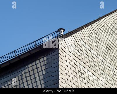 Façade en amiante d'un bâtiment résidentiel en Allemagne de l'est. Feuilles de ciment fibreuses grises comme revêtement sur un mur extérieur. Le matériau est dangereux. Banque D'Images