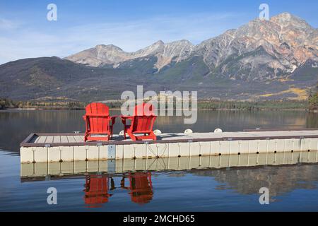 Chaises rouges sur un quai du lac Pyramid avec vue panoramique sur la montagne Pyramide dans les montagnes Rocheuses du parc national Jasper, Alberta, Canada Banque D'Images