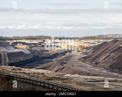 Mine en fonte ouverte pour l'extraction du charbon brun. Trou profond dans le paysage avec l'infrastructure pour le transport et la logistique. La nature détruite pour l'énergie Banque D'Images