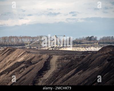 Machines minières dans une fosse ouverte. Équipement lourd pour le transport du lignite vers un tapis convoyeur. L'industrie exploite la nature. Banque D'Images