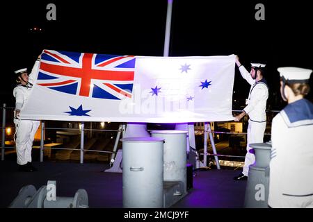 PEARL HARBOR (3 juillet 2022) l'enseigne blanche australienne est ornée d'un panneau de cérémonie lors d'un coucher de soleil de cérémonie dans le cadre de la réception nationale australienne tenue à bord du quai d'atterrissage pour hélicoptère de la Marine royale australienne HMAS Canberra (L02) à la base conjointe Pearl Harbor-Hickam, Hawaï, pour la côte du Pacifique (RIMPAC) 2022. Vingt-six nations, 38 navires, quatre sous-marins, plus de 170 avions et 25 000 membres du personnel participent au programme RIMPAC de 29 juin au 4 août dans les îles hawaïennes et dans le sud de la Californie. Le plus grand exercice maritime international au monde, RIMPAC offre une formation unique o Banque D'Images