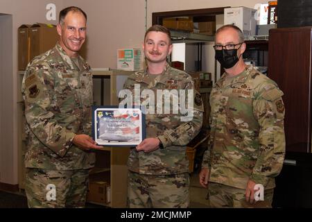 Le colonel Matt Husemann, à gauche, commandant de l’escadre du 436th aérotransport, présente le premier Airman Colton Day, au centre, du 436th e Escadron de soutien aux opérations, technicien en systèmes météorologiques radar, avec un certificat comme meilleur exécutant de la semaine sur la base aérienne de Douvres, Delaware (5 juillet 2022). Day a été inventé par Husemann et le Sgt. Timothy Bayes, à droite, chef de commandement 436th AW, pour des performances exceptionnelles. Banque D'Images