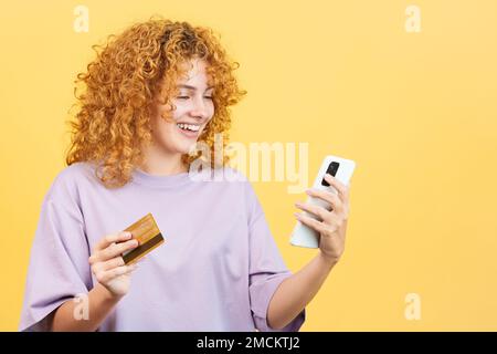 Femme utilisant une carte pour faire des achats en ligne avec le mobile Banque D'Images