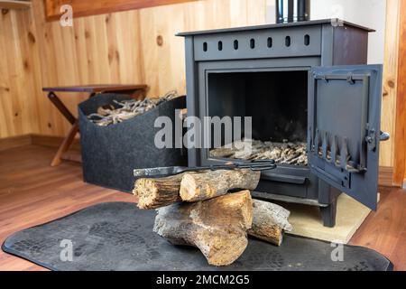 Poêle en bois rustique avec des bûches de bois prêtes à être introduites dans la cheminée. Banque D'Images