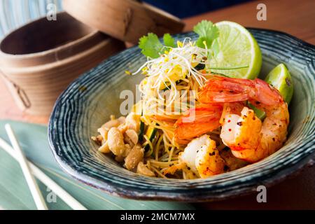 PAD thai, PAD thai ou PAD thai, est un plat de nouilles de riz sautées souvent servi comme nourriture de rue en Thaïlande dans le cadre de la cuisine du pays. Banque D'Images