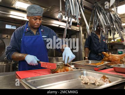 Spécialiste culinaire DE LA MER DES PHILIPPINES (6 juillet 2022) classe 2nd Levy Peterson, de Newark, New Jersey, coupe du jambon dans la galerie à bord du destroyer à missiles guidés de classe Arleigh Burke USS Benfold (DDG 65). Benfold est affecté au Commandant de la Force opérationnelle (CTF) 71/Destroyer Squadron (DESRON) 15, le plus grand DESRON déployé à l’avant de la Marine et la principale force de surface de la flotte américaine 7th. Banque D'Images