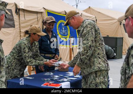 220707-N-UM706-1053 SAN DIEGO (7 juillet 2022) le sous-amiral Christopher Alexander, commandant de la Force opérationnelle combinée 177, examine les pièces de défi de commandement vendues par des officiers affectés au quai de transport amphibie de classe San Antonio USS Portland (LPD-27), pendant la Rim du Pacifique (RIMPAC) 2022 dans le sud de la Californie. Vingt-six nations, 38 navires, quatre sous-marins, plus de 170 avions et 25 000 membres du personnel participent au programme RIMPAC de 29 juin au 4 août dans les îles hawaïennes et dans le sud de la Californie. Le plus grand exercice maritime international au monde, RIMPAC fournit une onu Banque D'Images