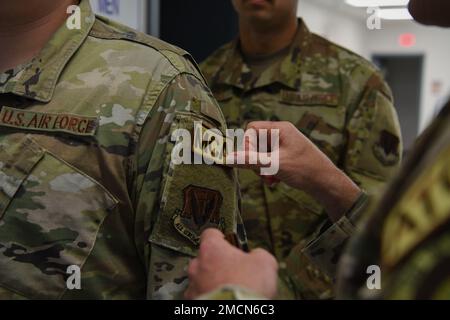 ÉTATS-UNIS Le Sgt Christopher Wlodarczyk, chef de commandement de l’escadre de reconnaissance de 319th, place une plaque Airman multi-capable sur l’épaule des États-Unis Airman Dakota Mills, principal de la Force aérienne, distributeur de carburants au 7 juillet 2022 de l'escadron de préparation logistique 319th, à la base aérienne de Grand Forks, Dakota du Nord. Le patch signifie que le cours Airman multi-capable est terminé et que plus de 150 fonctions ont été acquises dans plusieurs domaines de carrière. Banque D'Images