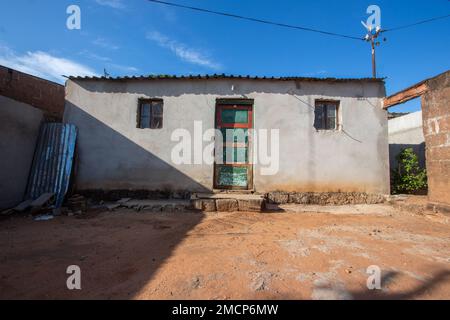 Une maison suburbaine africaine typique à Soweto avec des murs en béton et un toit en tôle de zinc, montrant des signes d'usure par les conditions météorologiques et le manque de résilience Banque D'Images