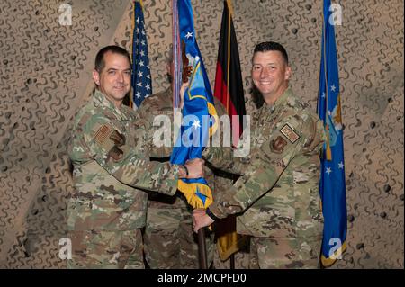 ÉTATS-UNIS Le colonel de la Force aérienne, Bryan T. Callahan, commandant de l'escadre des opérations aériennes au sol 435th et de l'escadre expéditionnaire aérienne 435th, à gauche, présente les lignes directrices au colonel John J. Riester, commandant entrant du Groupe des communications aériennes et spatiales 435th, lors d'une cérémonie de changement de commandement à la base aérienne de Ramstein, en Allemagne, au 8 juillet 2022. Banque D'Images