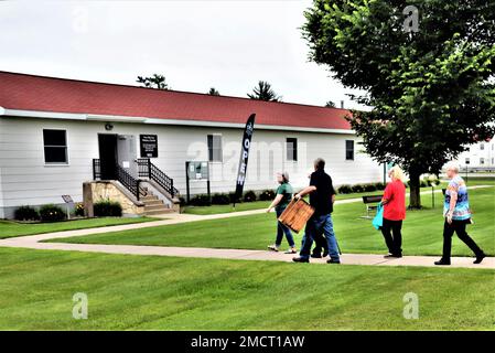 Un membre de la famille McCoy porte une caisse en bois datant de plus d'un siècle lors d'une visite à 8 juillet 2022, dans le Centre d'histoire de fort McCoy, dans la zone commémorative historique de fort McCoy, Wisconsin. La caisse a été donnée à fort McCoy par Alan McCoy, de Sparta, Wisconsin, qui est le petit-fils du major général Robert Bruce McCoy dont le nom est donné à fort McCoy. La caisse, qui transportait autrefois des seaux de saindoux, remonte à l'époque de Camp Emery Upton et Camp Robinson dans le Wisconsin vers 1910. Banque D'Images